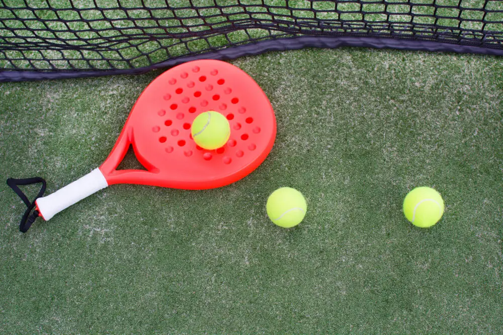 Padel balls on a red padel racket